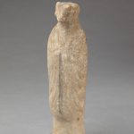 Figure with the head of a goat, one of a set of twelve representing the signs of the zodiac. Earthenware with traces of pigment over a white slip. It is represented as a human figure with the head of a goat, hands folded across the chest, draped in a long cloak.